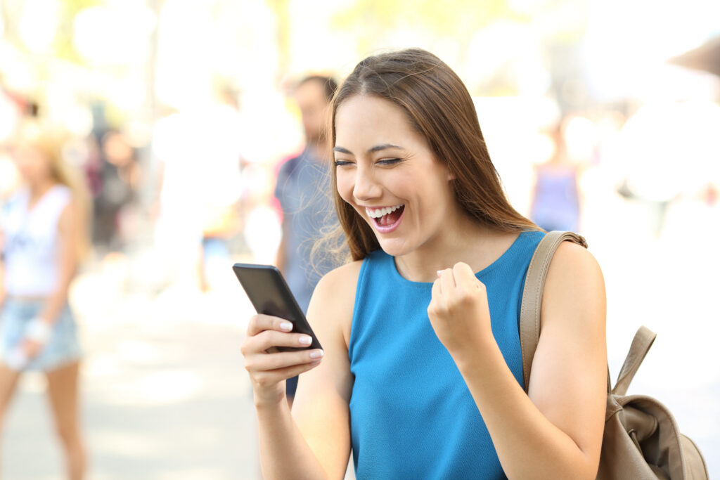 Excited woman using cursor control on her phone