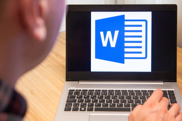Man looking at laptop with the Microsoft Word logo on the screen.