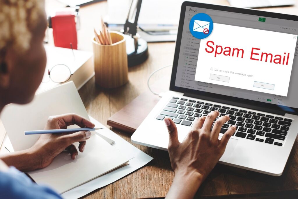 Woman working on laptop with spam email.