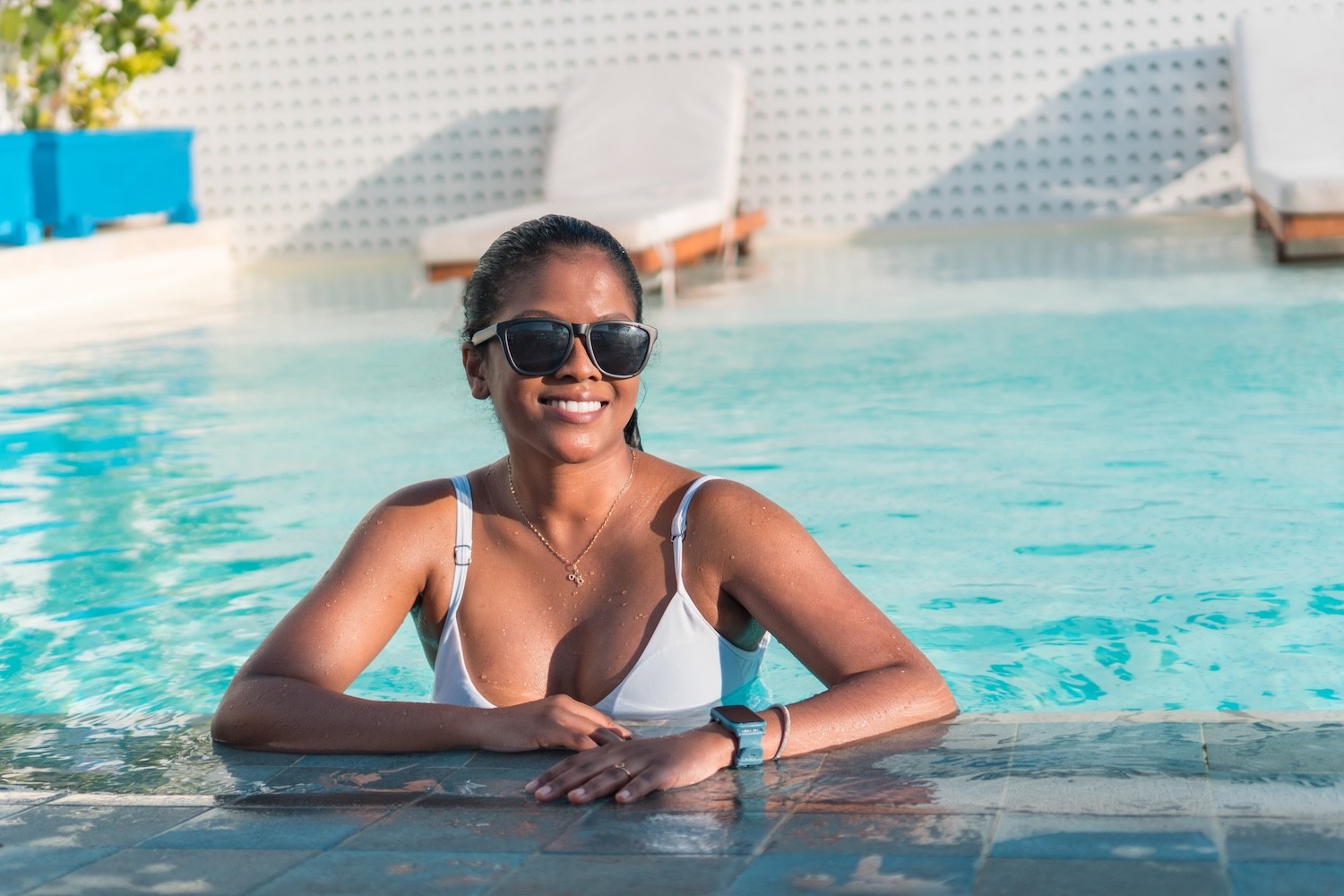 Beautiful woman relaxing poolside at a luxury resort. 