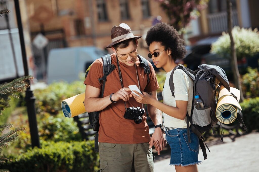 Young couple of tourists looking at a smartphone.