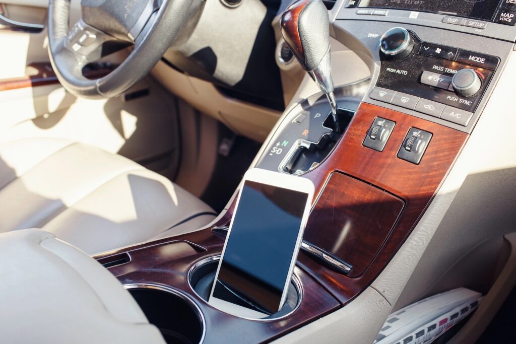 Smart phone on the car seat console.