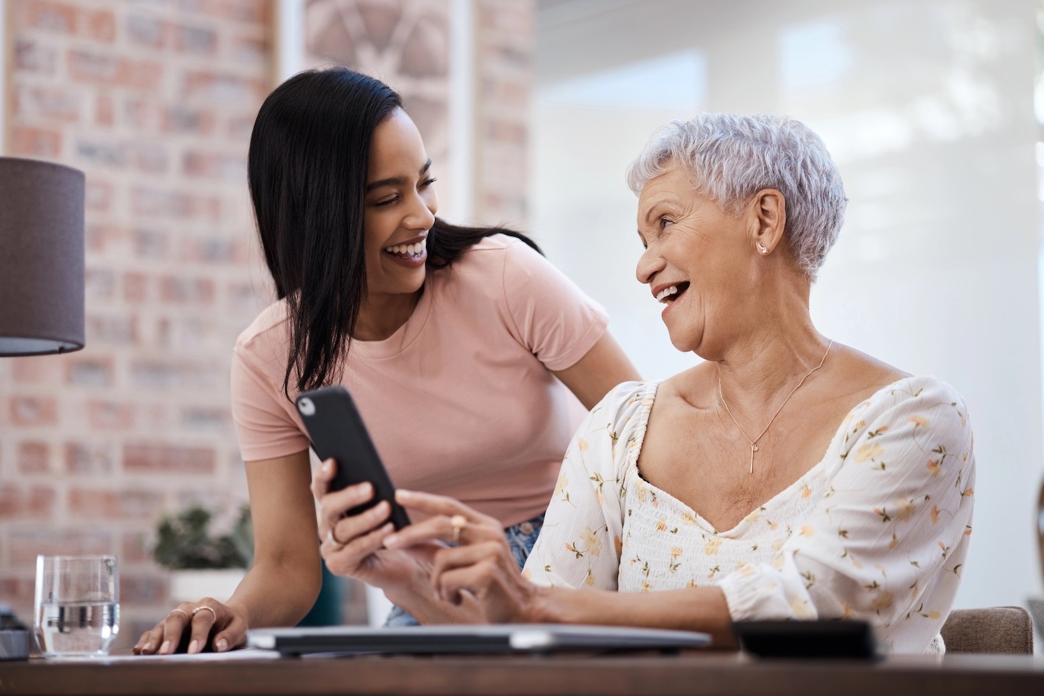Young woman helping her elderly mother with a smart phone. 