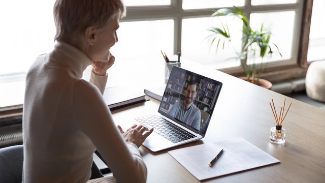 Businesswoman looking at laptop screen during video call. 