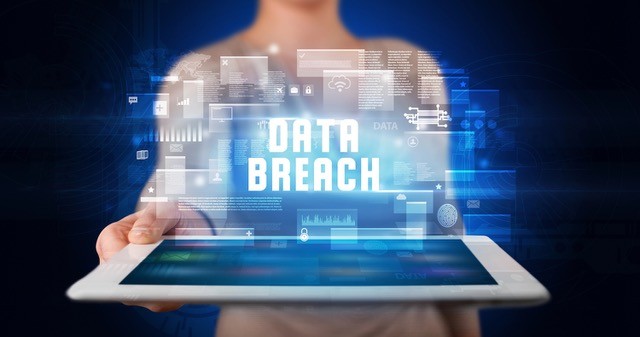 Person holding a tablet with data breach language.