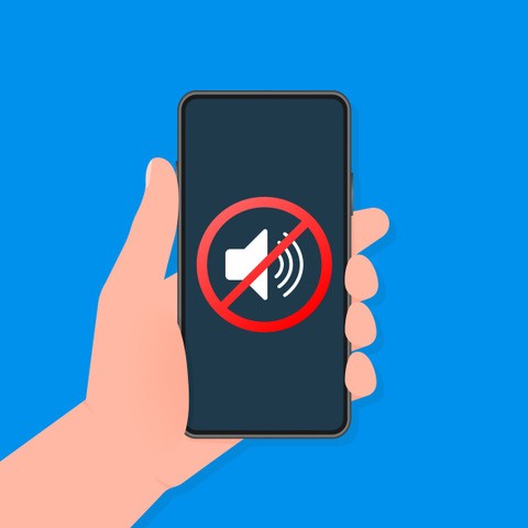 Hand holds a smart phone with no sound sign.