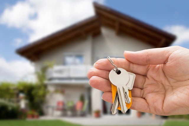 Close-up of a person's hand holding a house key.