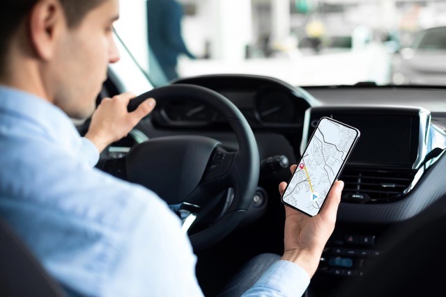 Man looking at map app while driving.