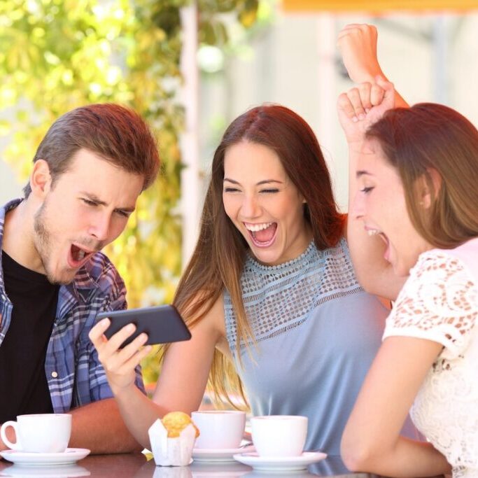 Three excited friends watching sports on a smart phone.