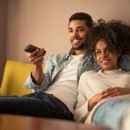 Cropped shot of a young african american couple watching television at home