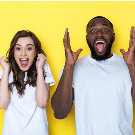 A man and woman standing side-by-side, with excited expressions, against a yellow background.