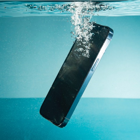 Modern Apple iPhone drowning in a tank of water.