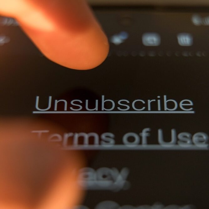 Close-up of a finger to tap the Unsubscribe link on a smartphone.