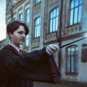 Girl wizard outside casting a spell with a magic wand.