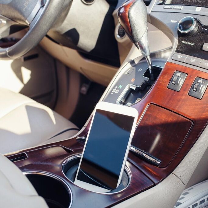 Smart phone on the car seat console.