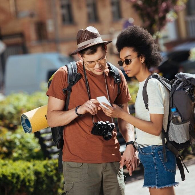 Young couple of tourists looking at a smartphone.