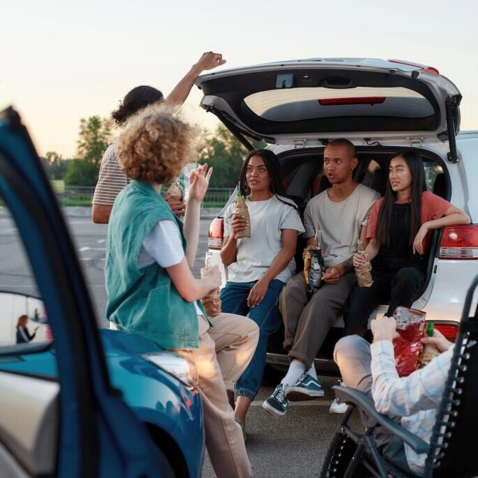 A group of young adults tailgating in a parking lot.