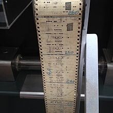 A program tape for the 1944 Harvard Mark I, one of the first digital computers. Note physical patches used to correct punched holes by covering them. Source: Wikipedia.